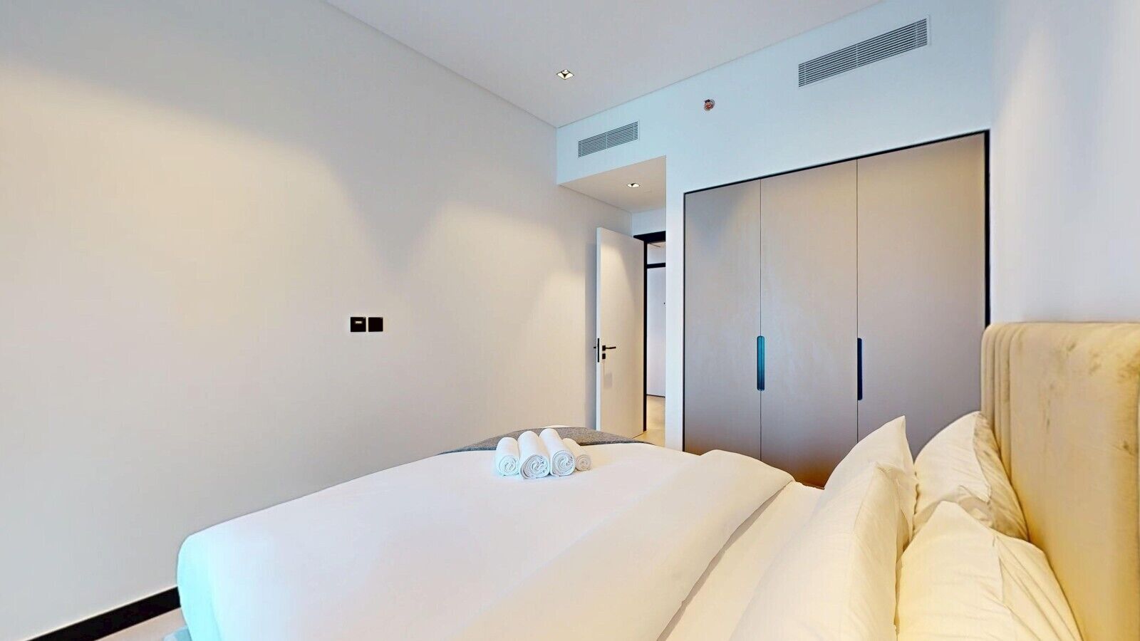 Une chambre d’hôtel avec un lit, une armoire et une porte donnant sur une autre pièce.