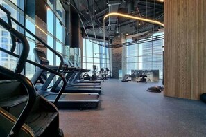 A gym with treadmills, exercise bikes, and weights. - Sleek 1 Bed with Burj Khalifa View l Business Bay (Business Bay)