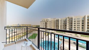Ein Balkon mit Blick auf einen Swimmingpool und angrenzende Gebäude.