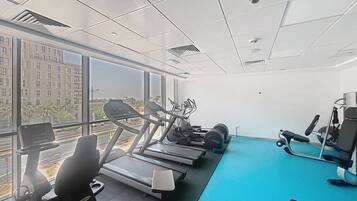 A gym with treadmills, elliptical machines, and weight equipment.