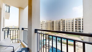A balcony with a view of a swimming pool and high-rise buildings. - Aesthetic 2 Bed in Townsquare l Pool and Gym (Town Square)