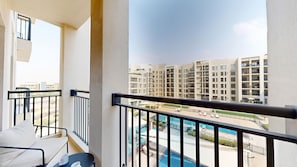 Ein Balkon mit Blick auf einen Swimmingpool und hohe Gebäude.