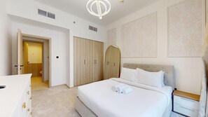 A hotel room with a large bed, a wardrobe, a bedside table, and a bathroom visible through an open door. - Aesthetic 2 Bed in Townsquare l Pool and Gym (Town Square)