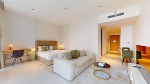 A hotel room with a bed, two bedside tables, a sofa, a coffee table, and a desk. - Chic Studio with Canal View l Business Bay (Business Bay)