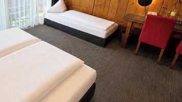 A hotel room with two beds, a desk, a chair, and a television.