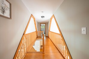 A wooden staircase with a railing, leading to an upper floor. - FirePit, Hot Tub, Dock + Lake "Get Your Creek On" (Swanton)