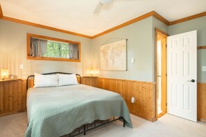 A bedroom with a bed, a window with curtains, a wall-mounted map, and a door. - FirePit, Hot Tub, Dock + Lake "Get Your Creek On" (Swanton)