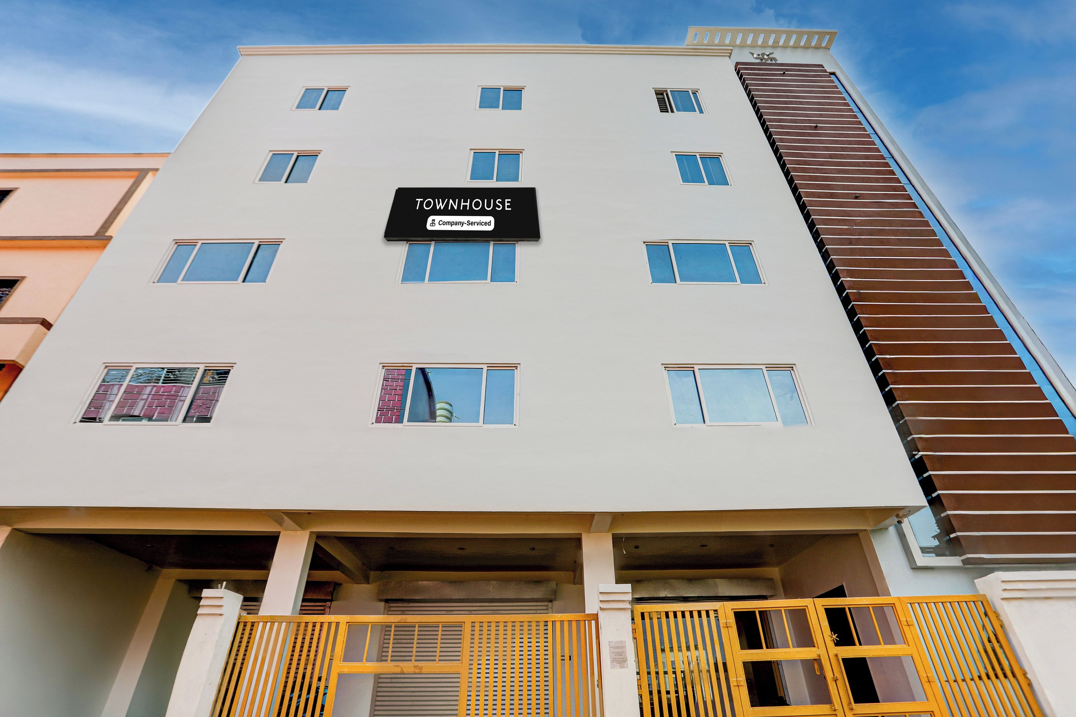 A multi-story building with a sign reading 'TOWNHOUSE Company Serviced.'