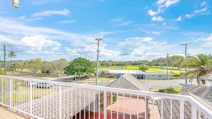 A residential area with a view of a golf course, a street, and a house with a balcony. - Shoreline Apartments - unit 13 (Bargara)