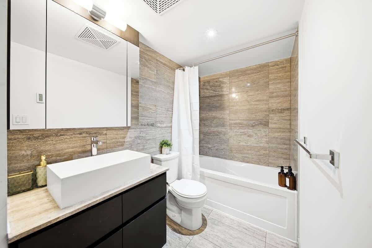 Ein modernes Badezimmer mit einem großen weißen Waschbecken, einer Toilette und einer Badewanne.