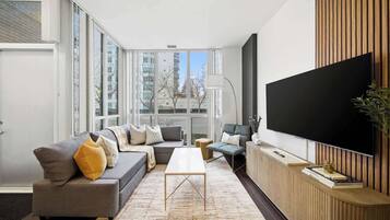 A modern living room with a sofa, coffee table, and a flat-screen TV.