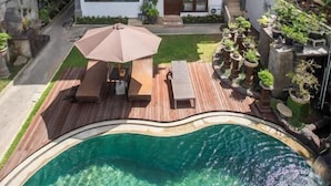 A two-story house with a swimming pool, outdoor seating, and a garden. - Pondok Bali 2 Homestay (Canggu)
