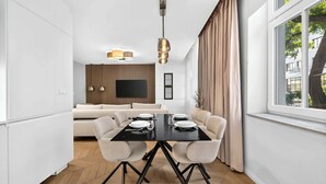 A modern dining area with a black table, white chairs, and a large window with curtains. - Designer Flagship for 6 - by Presidential Palace (Bratislava)