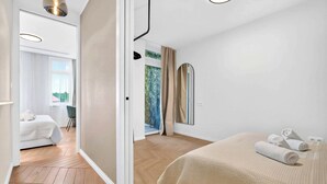 A modern hotel room with a bed, a bathroom, and a view of greenery. - Designer Flagship for 6 - by Presidential Palace (Bratislava)