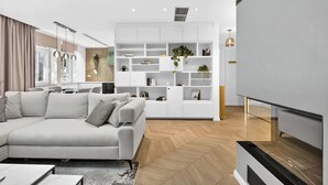 A modern living room with a sofa, a white shelving unit, and a staircase. - Designer Flagship for 6 - by Presidential Palace (Bratislava)
