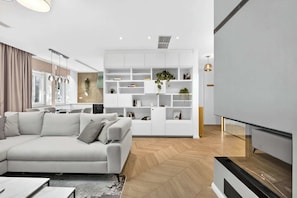 A modern living room with a sofa, a white shelving unit, and a staircase. - Designer Flagship for 6 - by Presidential Palace (Bratislava)