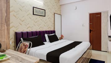 Un dormitorio con cama, mesita de noche, espejo y puerta.