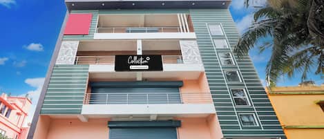 A multi-story building with a sign indicating it is a company-serviced collection.