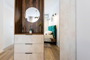 Ein Schlafzimmer mit Bett, Nachttisch und Spiegel über einer Kommode mit Schubladen.