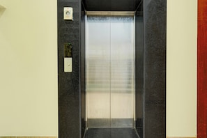 An elevator with a metallic interior and a control panel on the wall. - Hotel O AIIMS Bhubaneshwar (Bhubaneshwar)