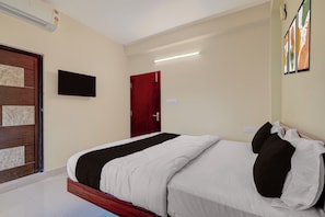 A hotel room with a bed, a television mounted on the wall, and a door. - Hotel O AIIMS Bhubaneshwar (Bhubaneshwar)