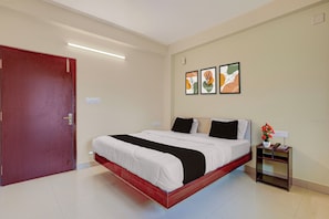 A hotel room with a bed, a nightstand with a phone, and a door. - Hotel O AIIMS Bhubaneshwar (Bhubaneshwar)