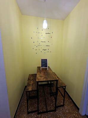 Ein Zimmer mit einem Holztisch und einem Schild mit Kreidezeichen.