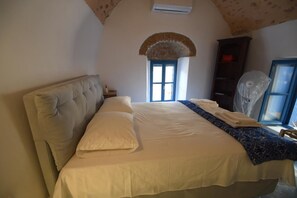A bedroom with a bed, a wardrobe, and a window with a view. - Avgonima Joy Medvial Suite (Chios)