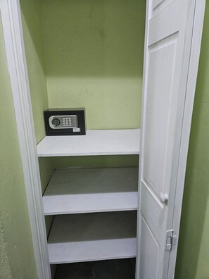 Ein Stauraum mit weißer Tür und einem Regal mit einem Radio.
