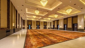 A spacious hotel lobby with a large carpeted area, multiple doors, and decorative lighting fixtures. - NANDGAON KASHI RESORT AND SPA (Varanasi)