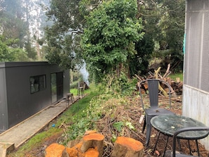 A garden area with a small shed, a chair, and a table.