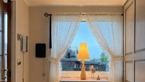 A room with a window, a lamp, a small table, and a white cabinet. - Spacious Home in Sudndalen at the Foot of Hallingskarvet (Hol)