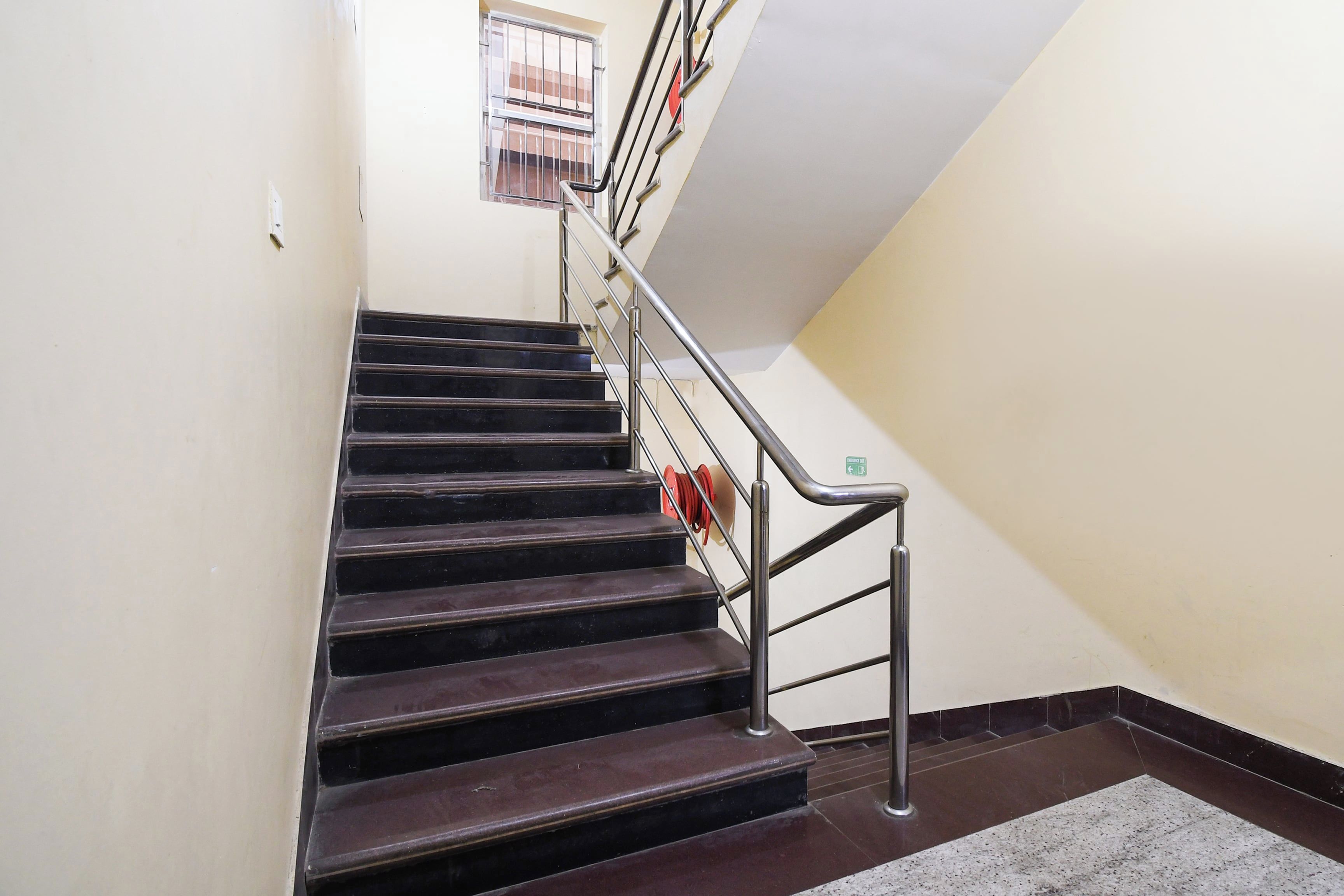 Una escalera con barandales de metal y pasamanos, que conduce a un piso superior.