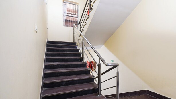 A staircase with metal railings and a handrail, leading to an upper floor. - Hotel O Indira Park Road Bhubaneswar (Bhubaneshwar)
