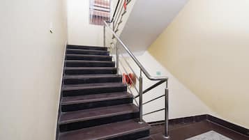 Una escalera con barandales de metal y pasamanos, que conduce a un piso superior.