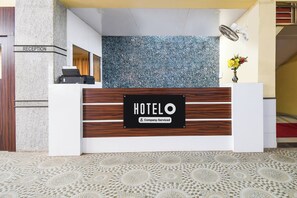 A reception desk with a sign that reads 'HOTELO Company-Serviced'.