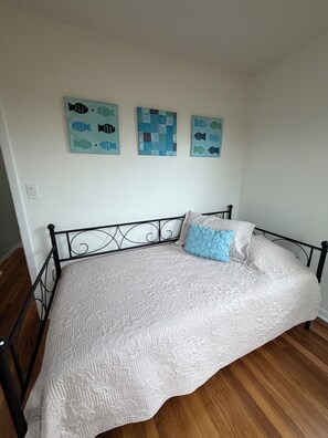 A bedroom with a bed, a headboard, and three wall-mounted paintings. - Launch Retreat on Merritt Island - Escape to the heart of Florida's Space Coast (Merritt Island)