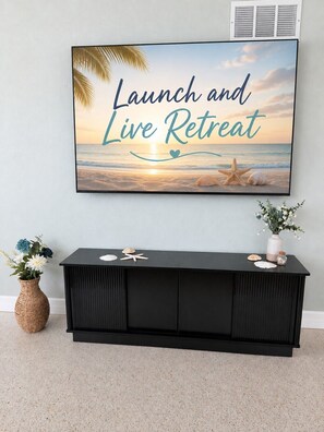 A framed motivational quote 'Launch and Live Retreat' above a black console table with decorative items. - Launch Retreat on Merritt Island - Escape to the heart of Florida's Space Coast (Merritt Island)