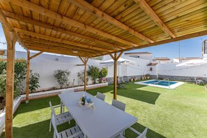 A covered outdoor patio with a pool, seating, and potted plants. - MalagaSuite Villa Flor de Piedra (Fuente de Piedra)