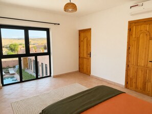 A bedroom with a large window, a wooden door, and a bed. - Villa Tawar - Marrakech (Marrakech)