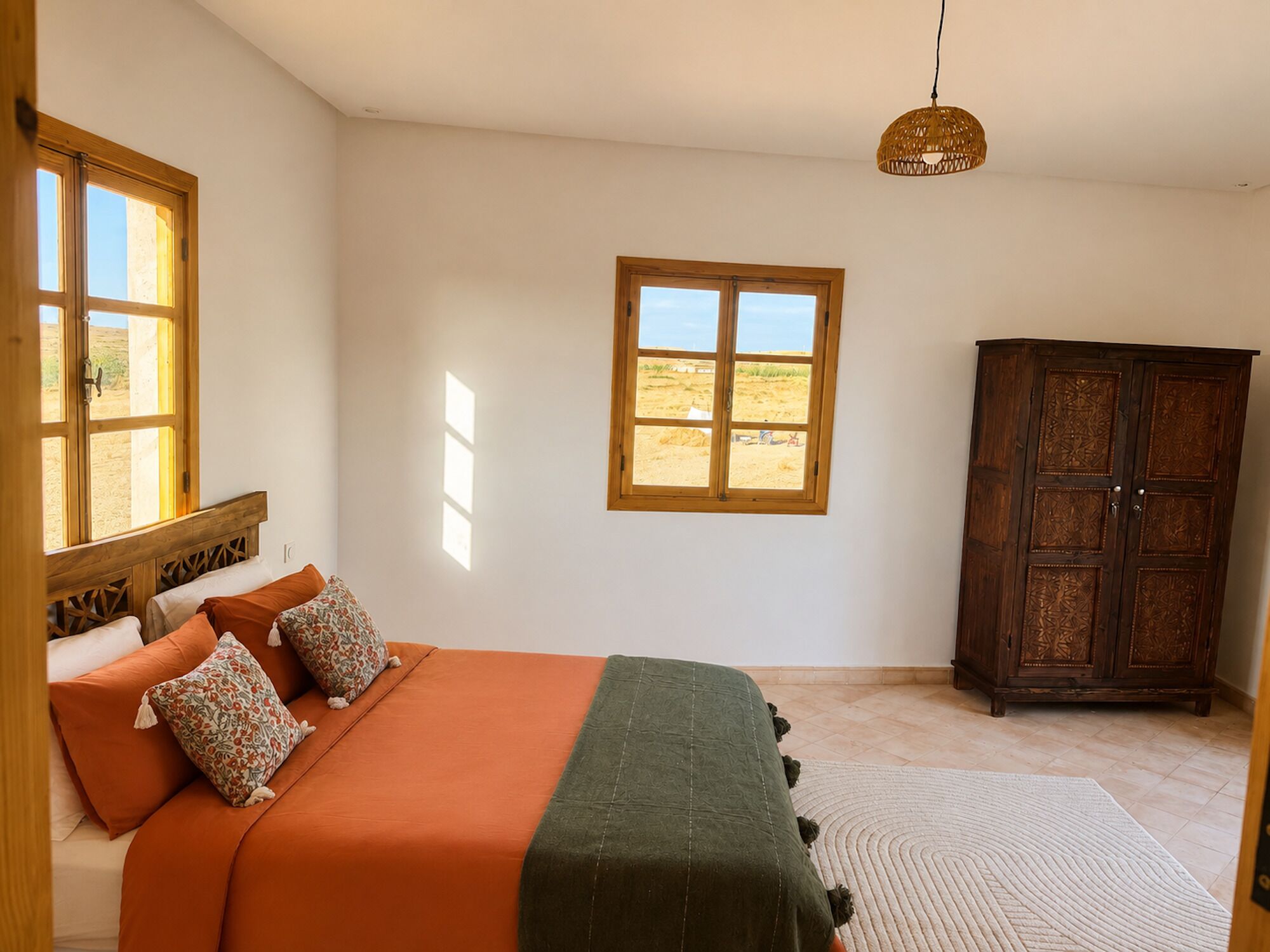 Ein Schlafzimmer mit einem Bett, einem Fenster, einem Schrank und einer Hängeleuchte.