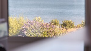 Blick auf das Meer durch ein Fenster mit Holzrahmen.