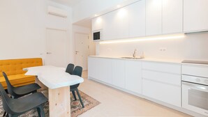 A modern kitchen with white cabinets, a built-in microwave, and a stainless steel oven.
