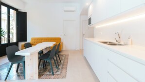 A modern kitchen with white cabinets, a built-in oven, and a stainless steel sink.