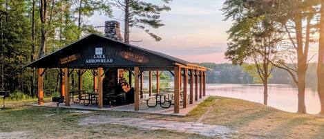 A rustic pavilion with a sign indicating directions to 'Turn Here' and 'Turn Left' for 'Lake Arrowhead'.