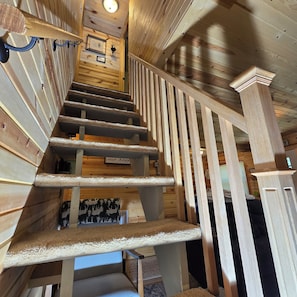 A wooden staircase with a handrail and a wall-mounted picture frame. - Cozy Hideaway 3-bedroom cabin in charming Gaylord (Gaylord)