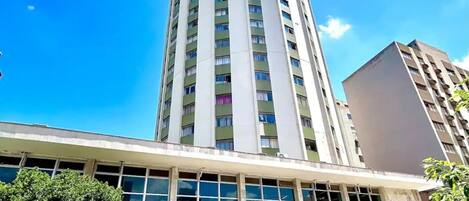 A tall building with a modern design, featuring a flat roof and a series of windows.