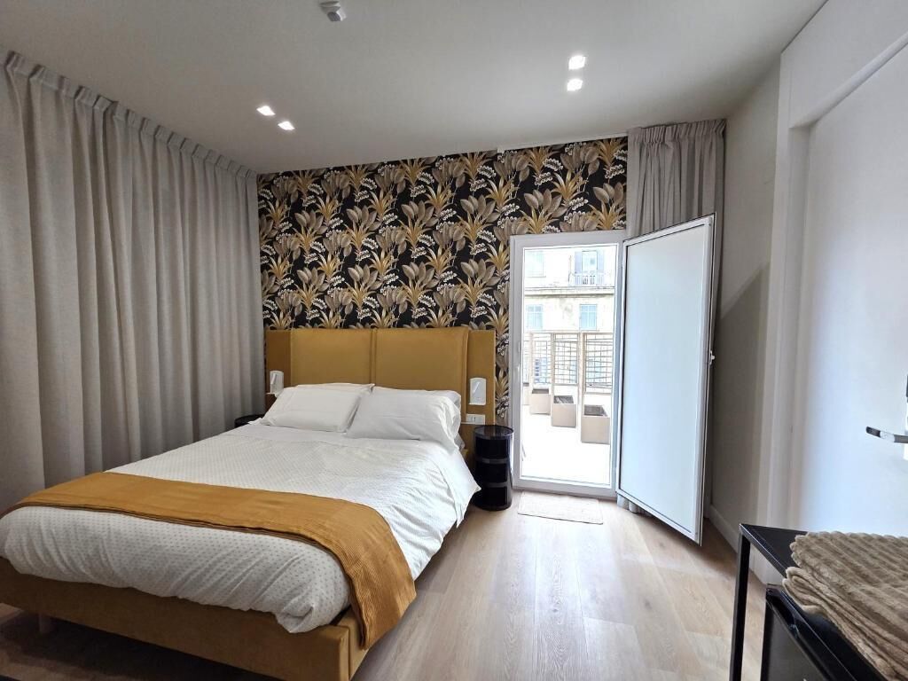 A modern bedroom with a bed, a wardrobe, and a view through a door.