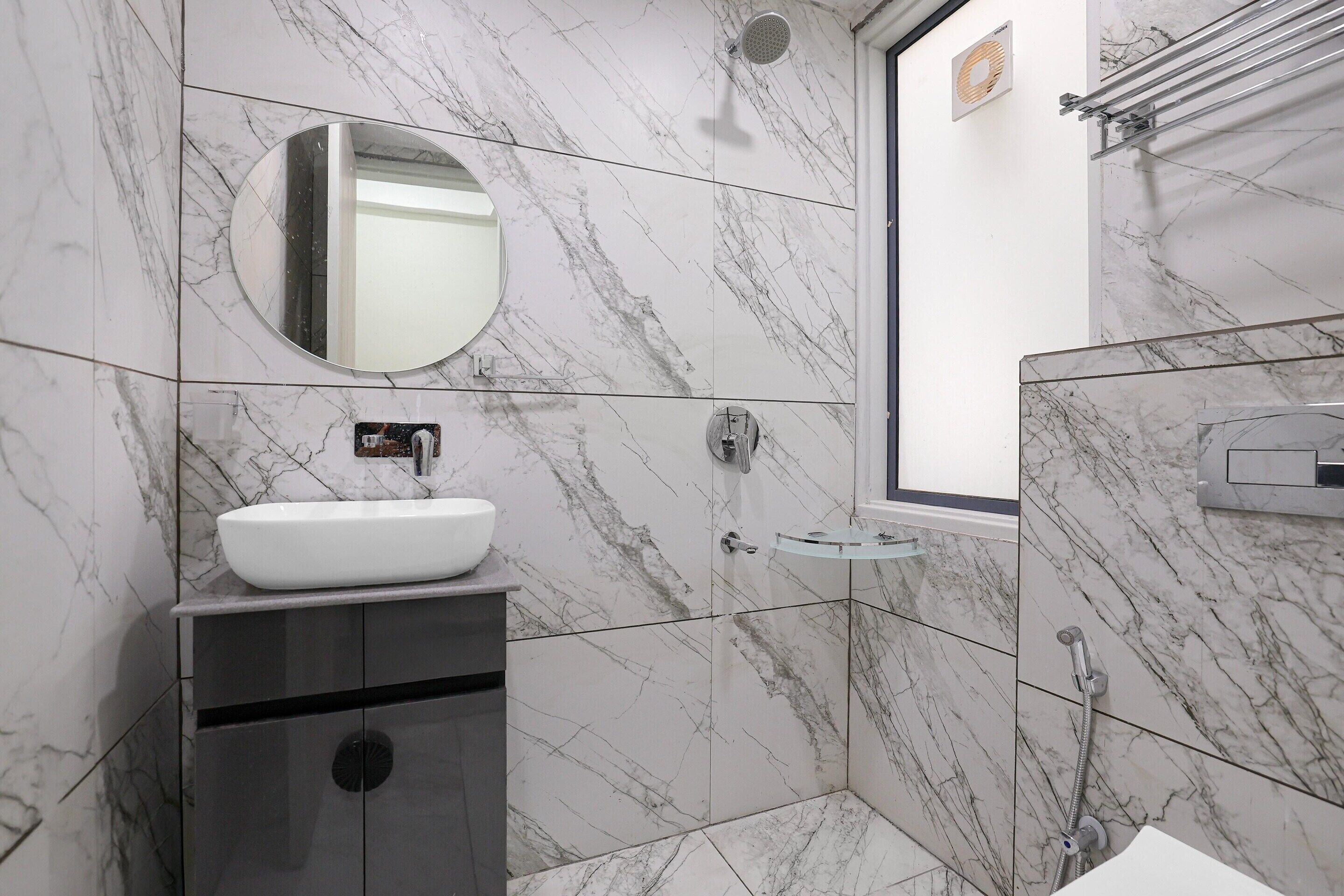 A bathroom with a white sink, a mirror, and a shower area.