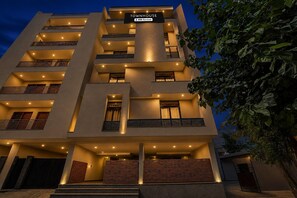 A multi-story hotel with balconies, a sign indicating it is serviced by OVO, and a gated entrance. - Classic With Balcony Townhouse Sector 52 (Gurugram)
